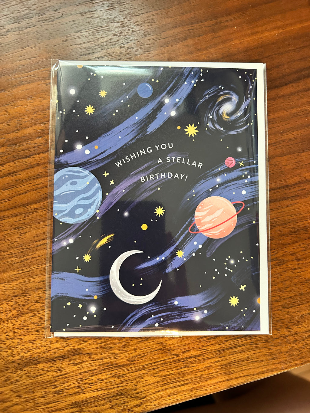 Space-themed birthday greeting card featuring colorful planets, stars, galaxies, and the message "Wishing You a Stellar Birthday!" on a navy blue night sky background.