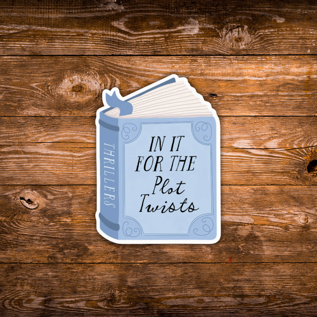 A die-cut sticker shaped like an open book with the text 'IN IT FOR THE Plot Twists' and 'THRILLERS' on the spine, shown on a rustic brown wooden plank background.