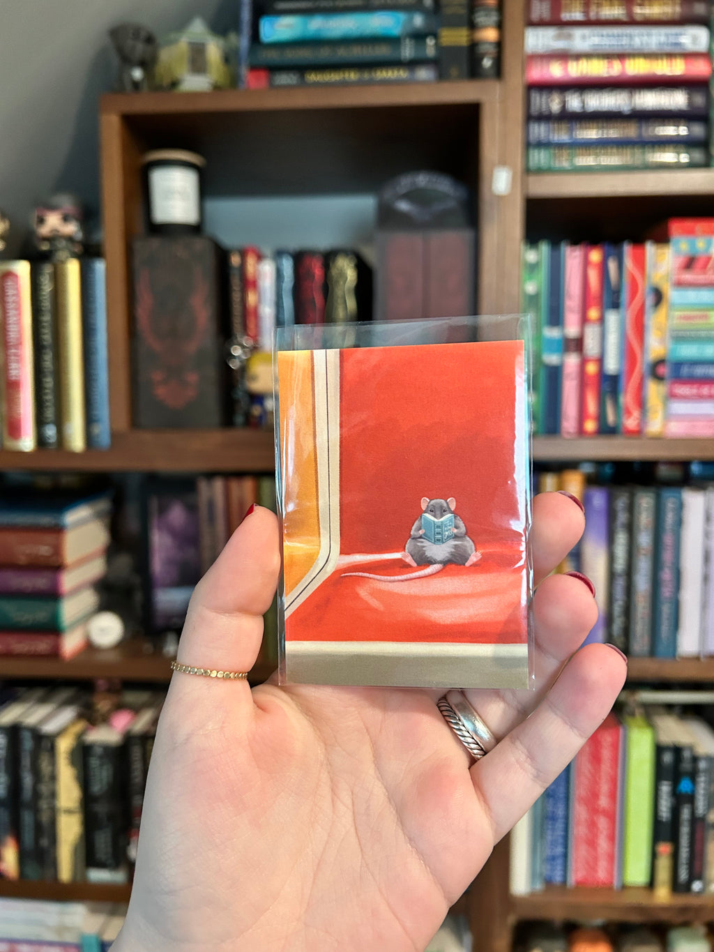 Mini art print featuring a small rat reading a book while sitting on an orange New York subway seat.