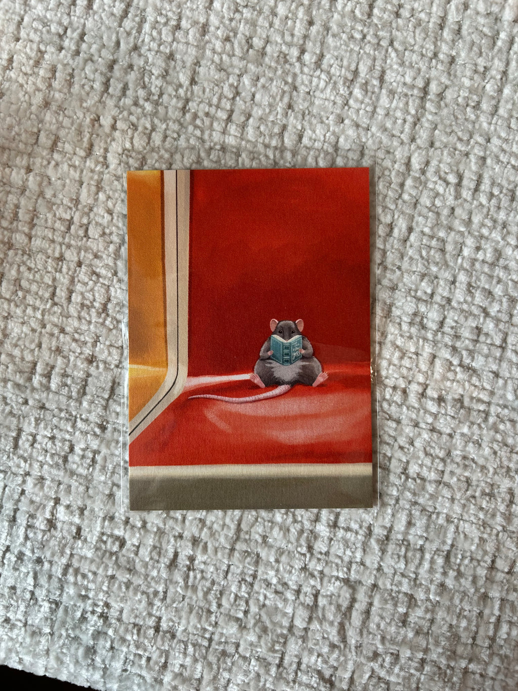 Mini art print featuring a small rat reading a book while sitting on an orange New York subway seat.