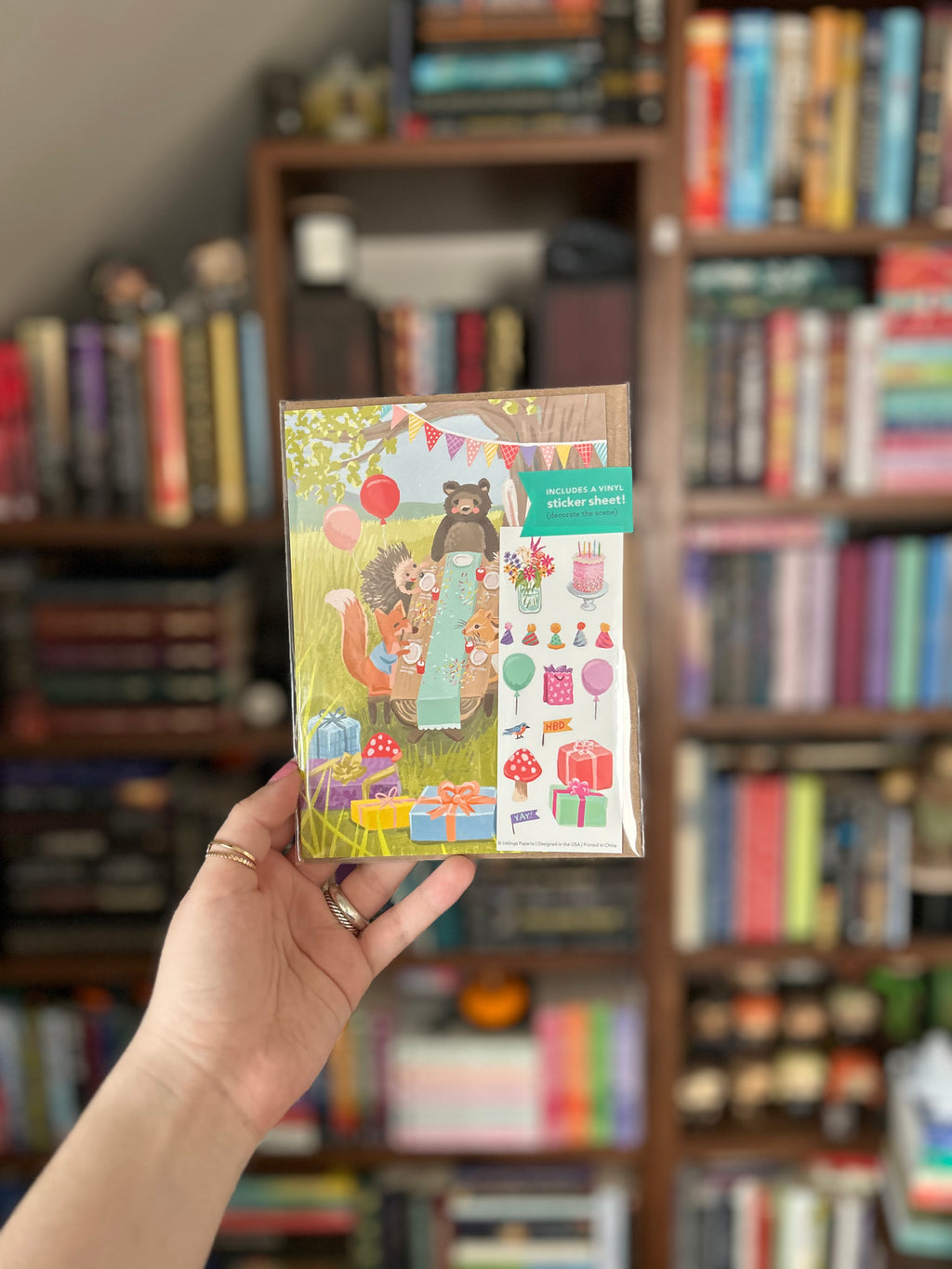 Woodland birthday greeting card featuring a bear, bunny, hedgehog, squirrel, and chipmunk celebrating at a picnic with balloons, presents, and a matching birthday sticker sheet.
